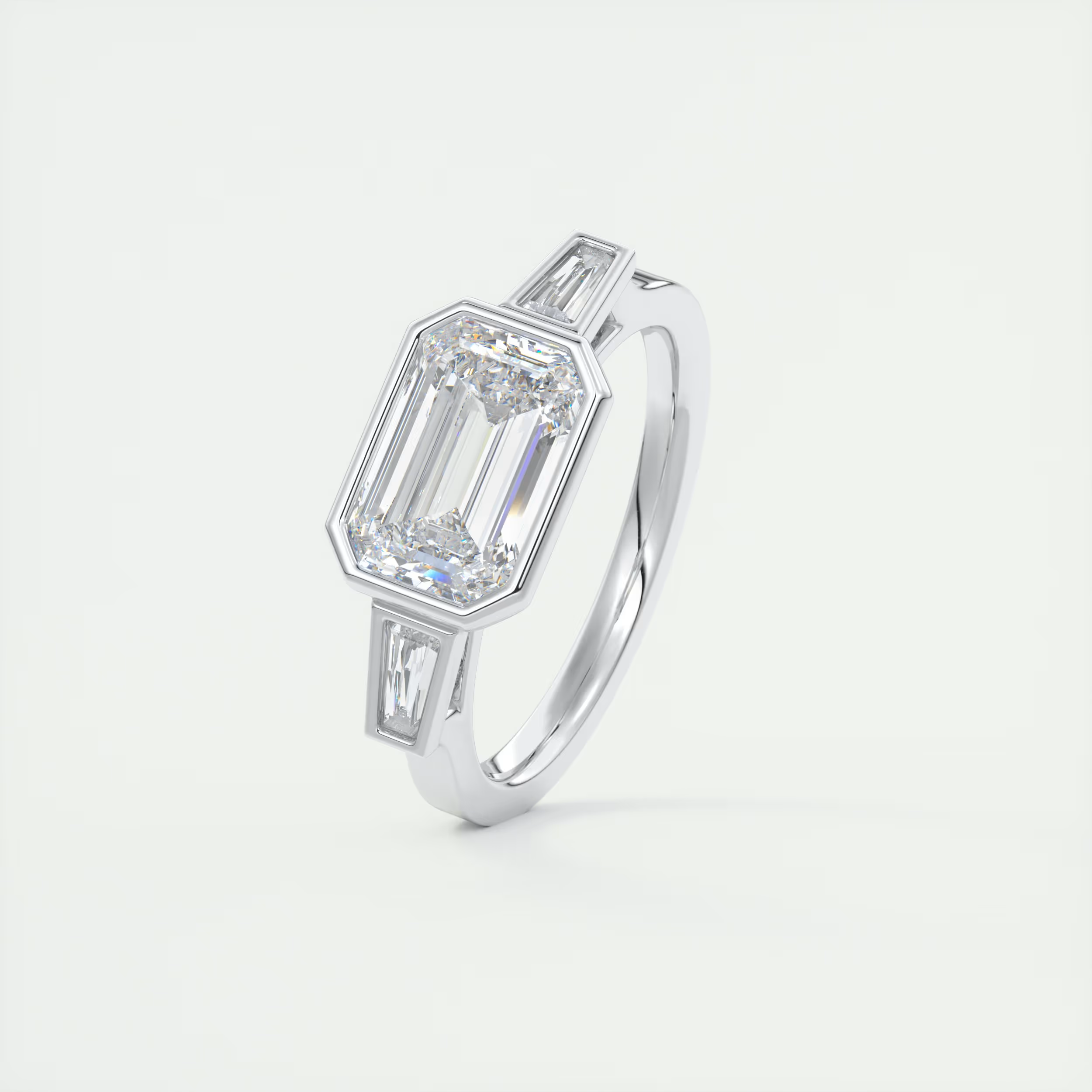 Elevated 2 Carat Emerald & Tapered Baguette Three-Stone Bezel Set Engagement Ring